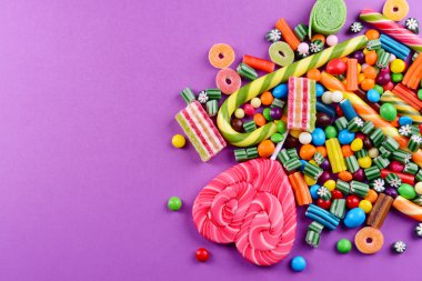 Mor arka plan üzerinde renkli şekerler