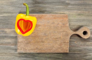 Ahşap arka plan üzerinde kalp şeklinde salata biber ile kesilmiş
