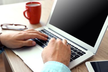 Dizüstü bilgisayarla çalışan adam