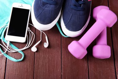 Hareket eden telefon ve kulaklık ile spor için ahşap masa, closeup ayarla