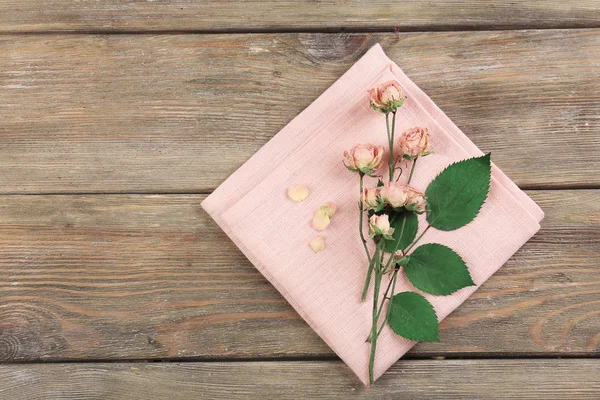 Bellissimi fiori secchi su tovagliolo su sfondo di legno — Foto Stock