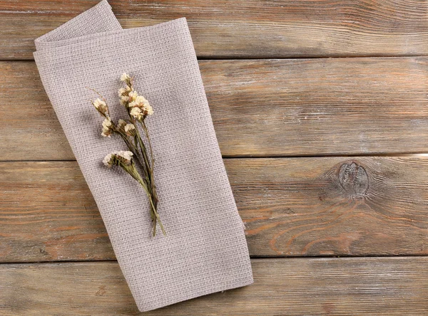 Mooie droge bloemen op servet op houten achtergrond — Stockfoto