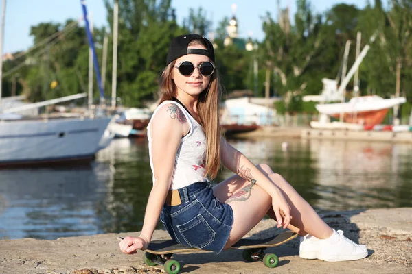 Menina tatuada bonita com skate, ao ar livre — Fotografia de Stock