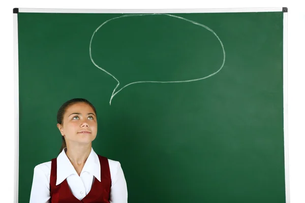 Vacker liten flicka står nära blackboard — Stockfoto