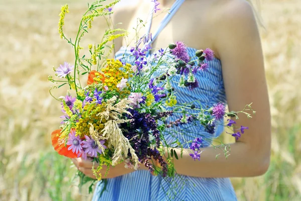 Mulher segurando buquê de flores silvestres — Fotografia de Stock