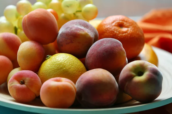 Montón de frutas frescas en bandeja en la mesa de madera de cerca —  Fotos de Stock