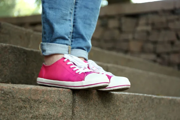 Pies femeninos en zapatos de goma rosa — Foto de Stock