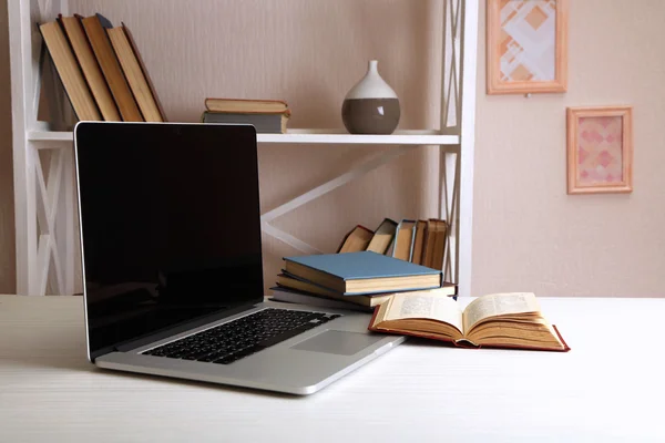 Ordinateur portable avec livres sur la table — Photo