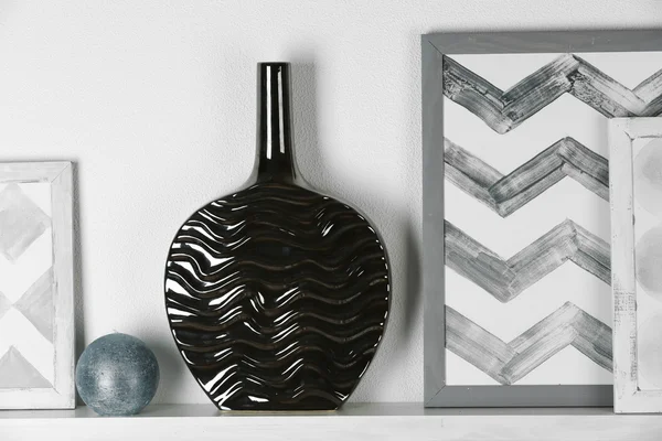 Modern vase with picture on shelf — Stock Photo, Image