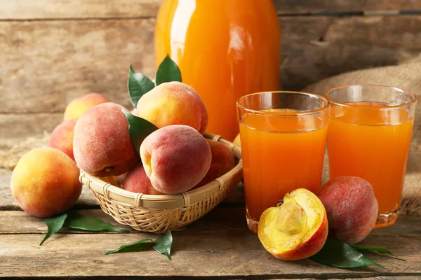 Ripe peaches and juice on wooden background — Stock Photo, Image