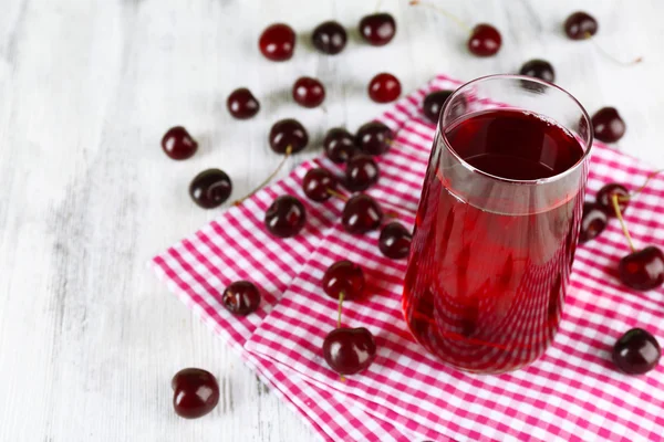 Sklenka cherry šťáva na dřevěný stůl, záběr — Stock fotografie