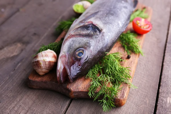 Snoekbaars vis en andere ingrediënten op houten tafel, close-up — Stockfoto