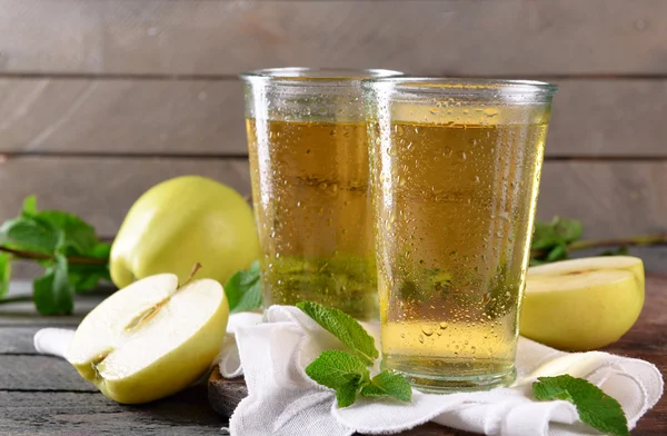 Wet glasses of apple juice on wooden background — Stock Photo, Image