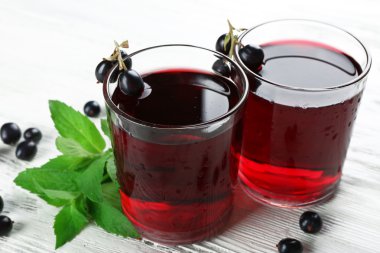 Arka plan bardak taze blackcurrant suyu ahşap masa