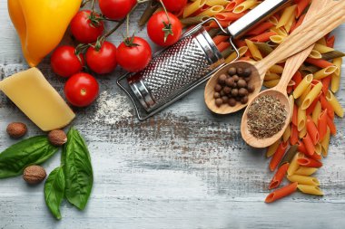 Domates, peynir ve fesleğen renk ahşap arka plan ile makarna penne