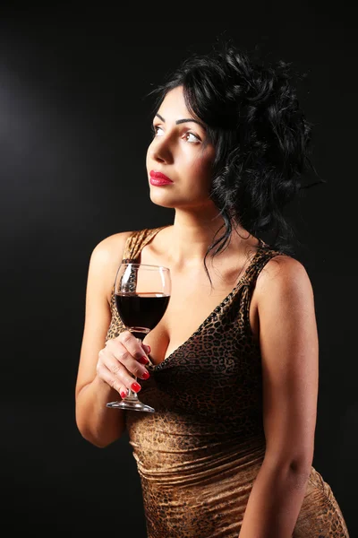 Mulher muito jovem com vinho no fundo preto — Fotografia de Stock