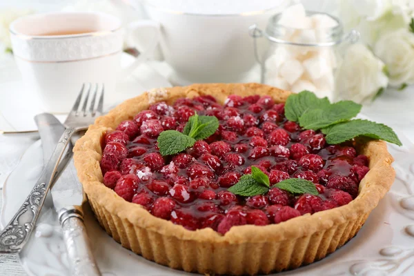 Tarta con frambuesas y sabroso té, sobre fondo de madera de color —  Fotos de Stock