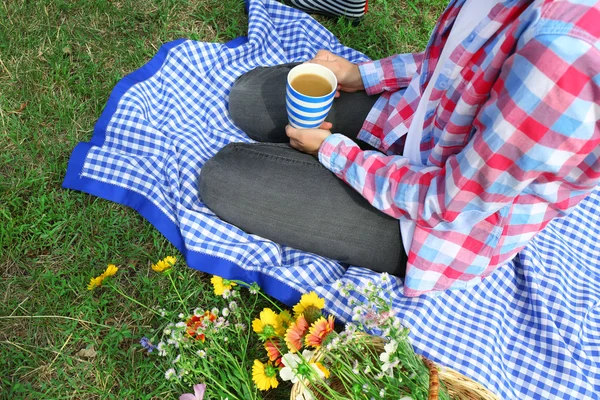 Woman with cup of coffee sitting on meadow — Stock Photo, Image
