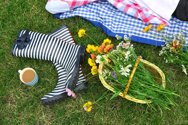 Fiori selvatici e stivali di gomma sul prato — Foto Stock