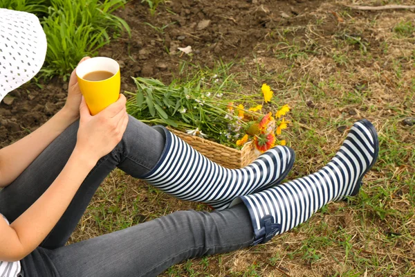 Wanita dengan secangkir kopi duduk di padang rumput — Stok Foto