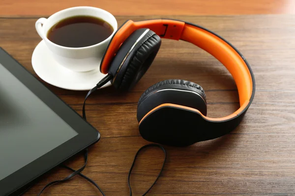 Fones de ouvido com tablet e xícara de café — Fotografia de Stock