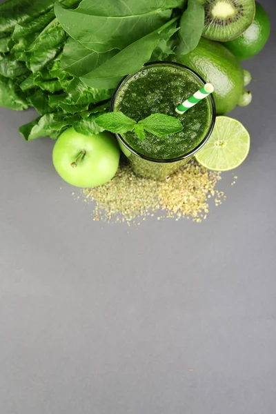 Groene gezond vruchtensap met groenten en kruiden op grijze achtergrond — Stockfoto