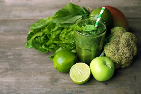 Yeşil sağlıklı suyu meyve ve sebzeler üzerinde ahşap masa ile yakın çekim — Stok fotoğraf