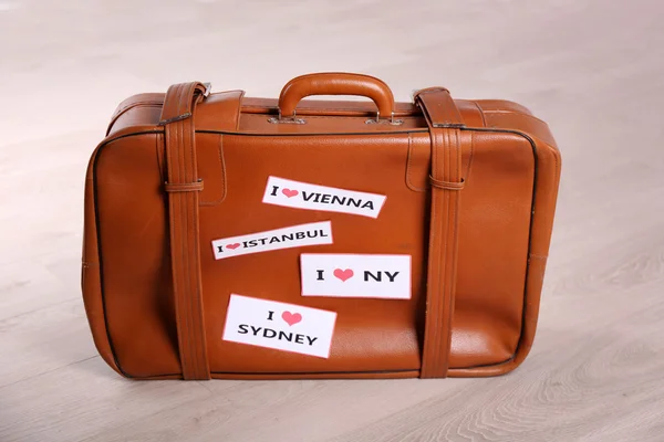Suitcase with stickers on floor — Stock Photo, Image