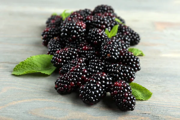 Heap of sweet blackberries with mint on wooden table close up — Stock Photo, Image