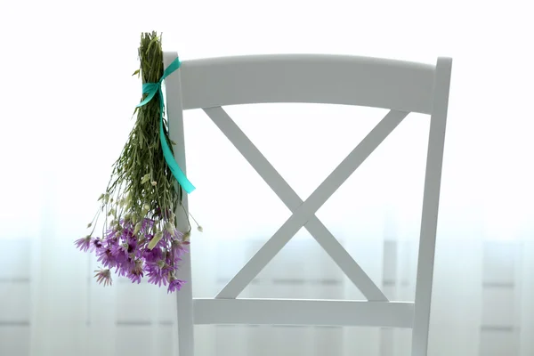 Bouquet of wild flowers drying on chair — Stock Photo, Image