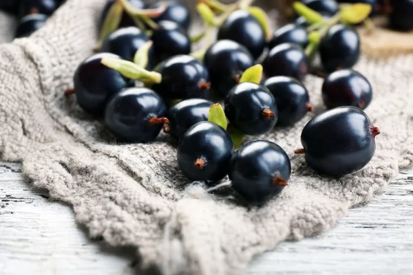 Ripe black currants on sackcloth, closeup — Stock Photo, Image