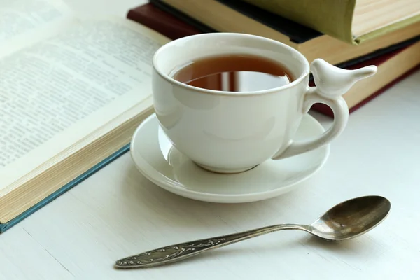 Tazza di tè con pila di libri sul davanzale della finestra, primo piano — Foto Stock