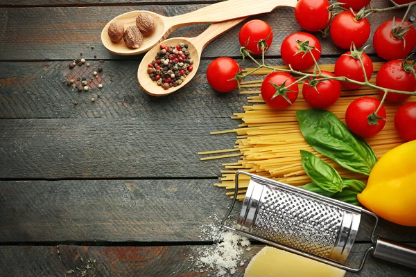Паста-спагетти с помидорами, сыром и базиликом на деревенском деревянном фоне — стоковое фото
