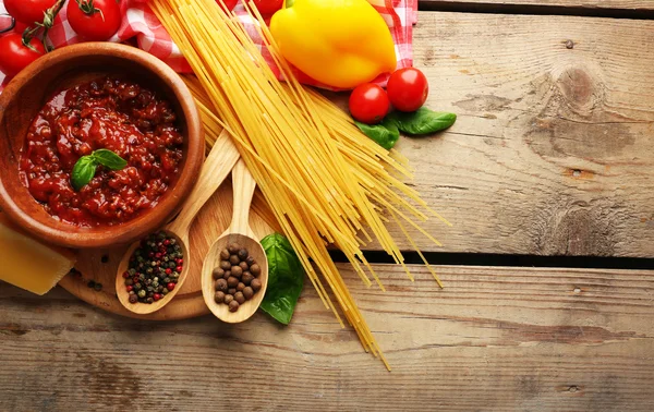 Espaguetis de pasta con tomates, salsa boloñesa, queso y albahaca sobre fondo rústico de madera — Foto de Stock