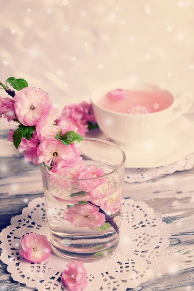 Красивый цветок фруктов в стекле и чашку чая на столе на светлом фоне — стоковое фото