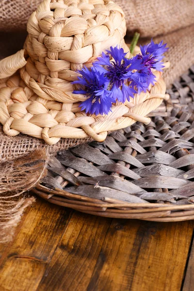 Cappello piccolo in paglia con fiordaliso su fondo legno — Foto Stock