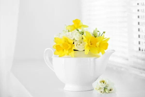 Beau bouquet de jonquilles jaunes et de roses en théière sur le rebord de la fenêtre — Photo