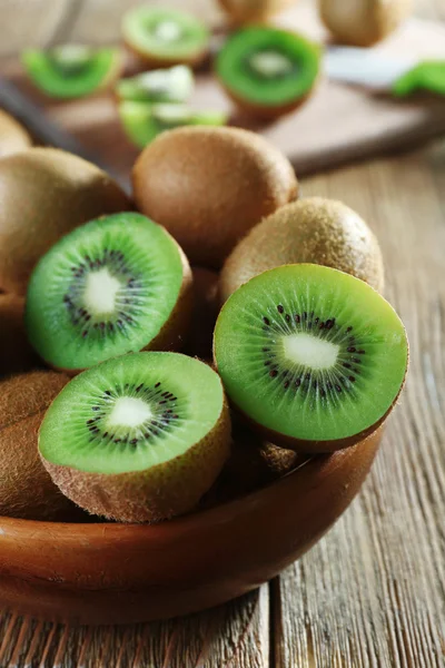 Jugosa fruta kiwi en un tazón sobre una mesa de madera — Foto de Stock