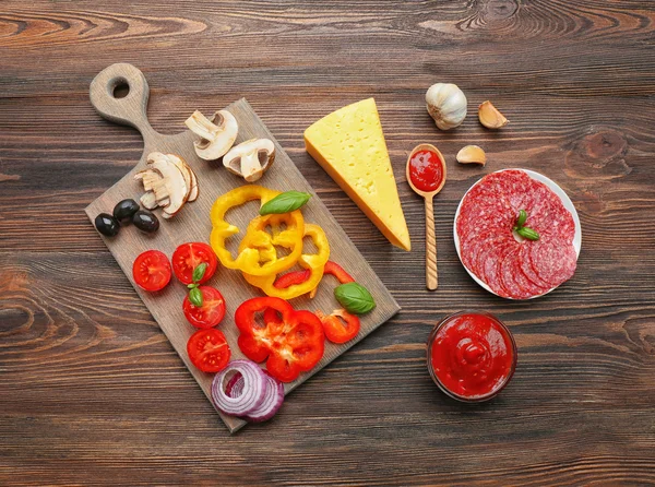 Ingredienser för matlagning pizza på träbord, ovanifrån — Stockfoto