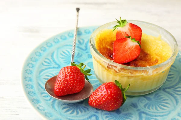 Sobremesa de brulee de creme com bagas de morango frescas em guardanapo, no fundo de madeira a cores — Fotografia de Stock