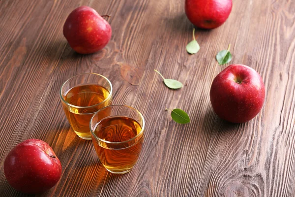 Copos de suco de maçã e frutas na mesa de perto — Fotografia de Stock