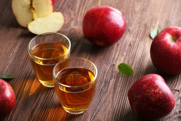 Bicchieri di succo di mela e frutta sul tavolo da vicino — Foto Stock
