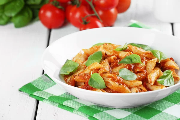 Pasta con salsa di pomodoro e basilico in tavola da vicino — Foto Stock