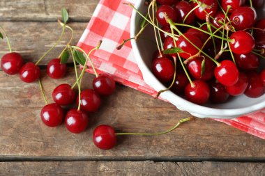 Ahşap arka plan üzerinde kase kiraz