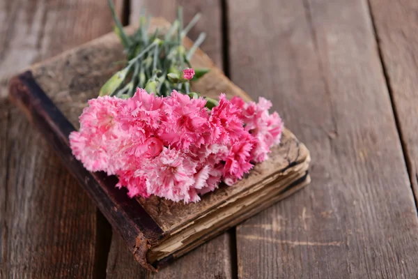 Gammal bok med vackra blommor på träbord nära håll — Stockfoto