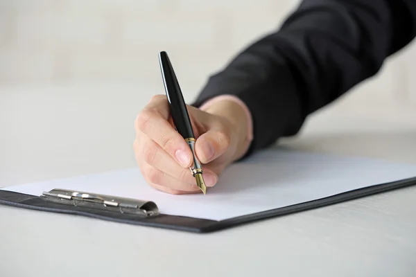 Vrouwelijke hand met pen op papier op werkplek schrijft — Stockfoto