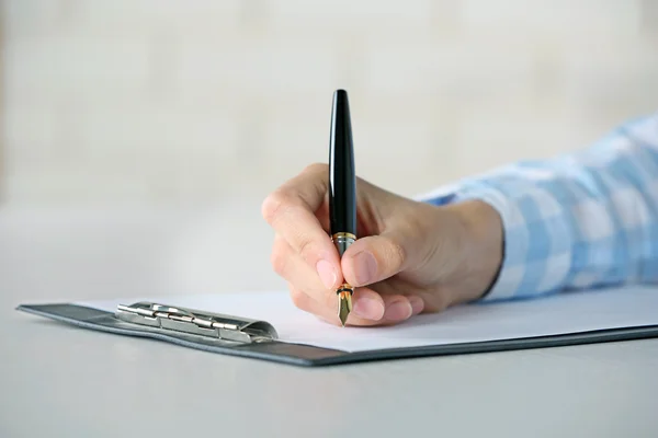 Vrouwelijke hand met pen op papier op werkplek schrijft — Stockfoto