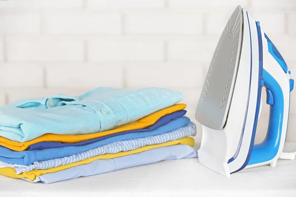 Roupa de engomar eletrônica e pilha de roupas — Fotografia de Stock
