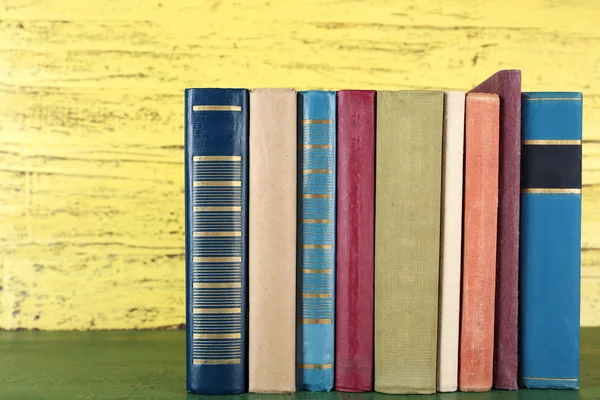 Libros retro sobre fondo amarillo de madera — Foto de Stock