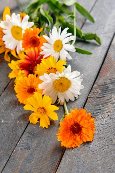Heldere wilde bloemen op houten tafel, close-up — Stockfoto